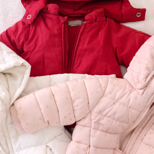 Tres anoraks acolchados para bebé en colores rojo, blanco con estrellitas grises y rosa con estrellas doradas, de las marcas Boboli y Freestyle.