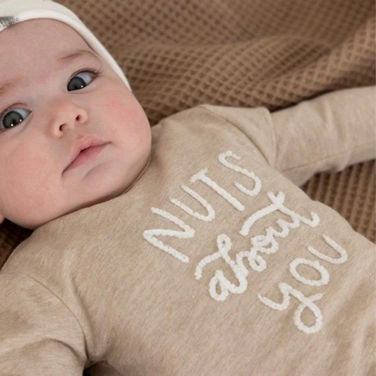  Bebé con camiseta beige bordada de Feetje con mensaje “Nuts About You”